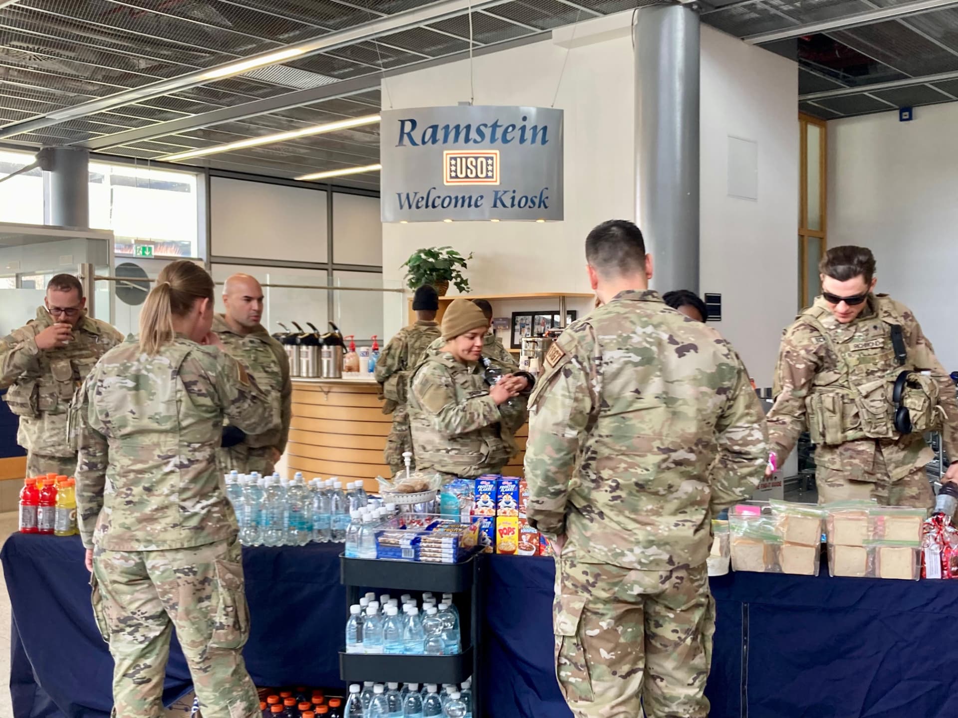 Service members gathering snacks and drinks at the Ramstein USO Welcome Kiosk.